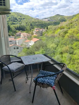 Furnished balcony with a table and chairs and a view of greenery and the neighborhood. - image 2