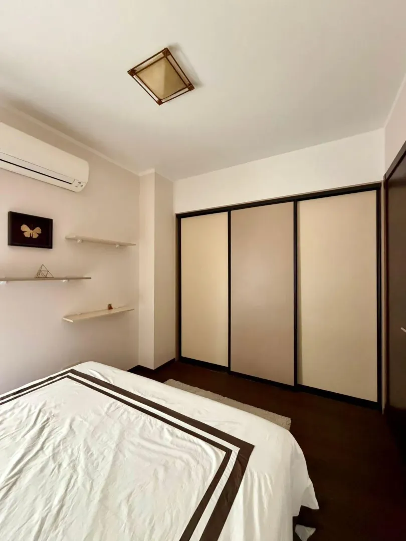 Tidy bedroom with a double bed, built-in wardrobe, and air conditioning.