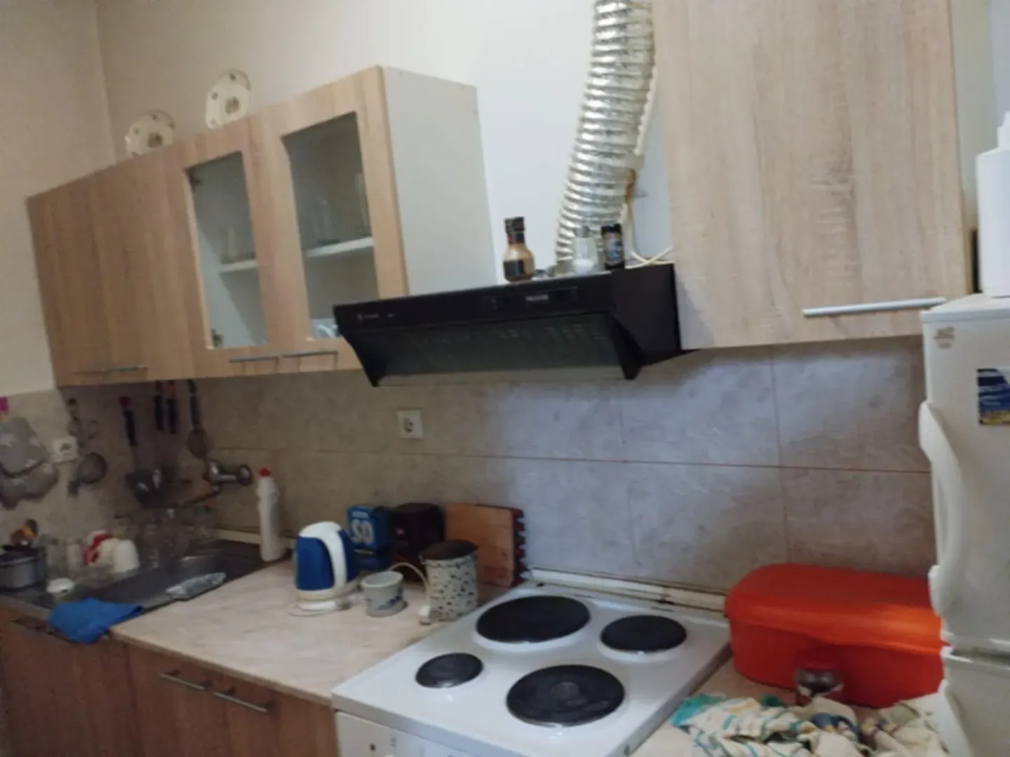 Manja kuhinja sa drvenim elementima i šporetom.