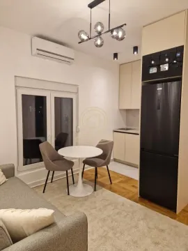 Moderna kuhinja sa trpezarijskim stolom i stolicama u sklopu dnevnog boravka. - image 2