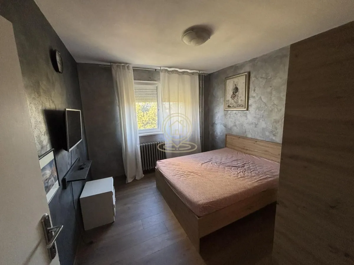 Bedroom with a double bed, TV, and a window.