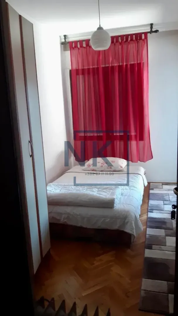 Manja spavaća soba sa krevetom i garderoberom.