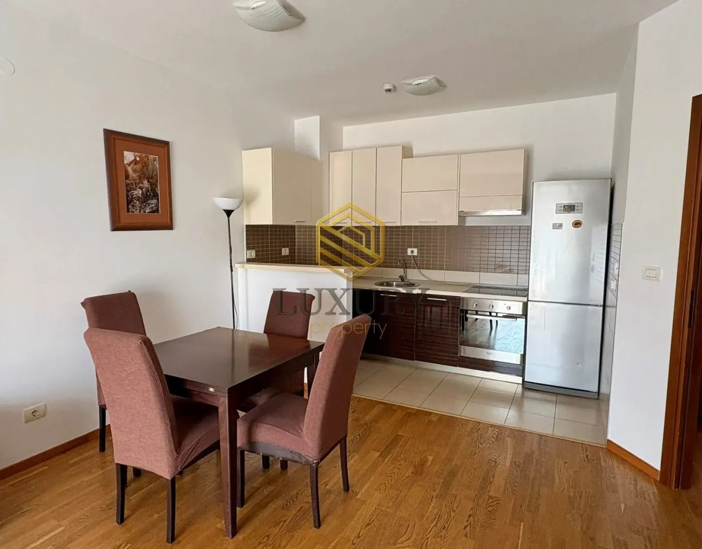 Small kitchen connected to the dining area with a wooden table and chairs.
