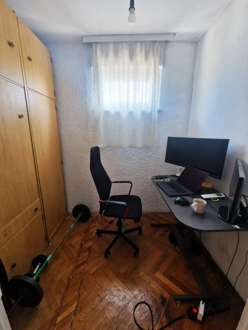 Manja soba opremljena kao radni prostor sa radnim stolom i garderoberom.