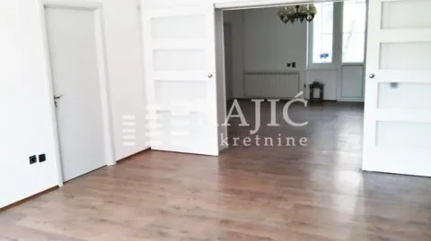 Spacious living room with wooden flooring and double sliding doors. - image 3