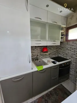 Manja kuhinja sa bijelim i sivim elementima, sudoperom i ugradnom pločom. - image 3