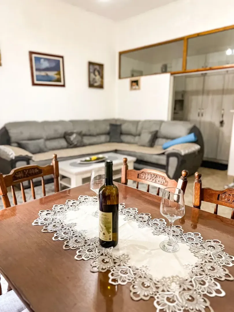Dining table with a bottle of wine and glasses in the living room.