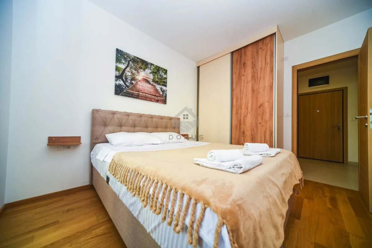 Furnished bedroom with a double bed, wardrobe, and a painting on the wall.