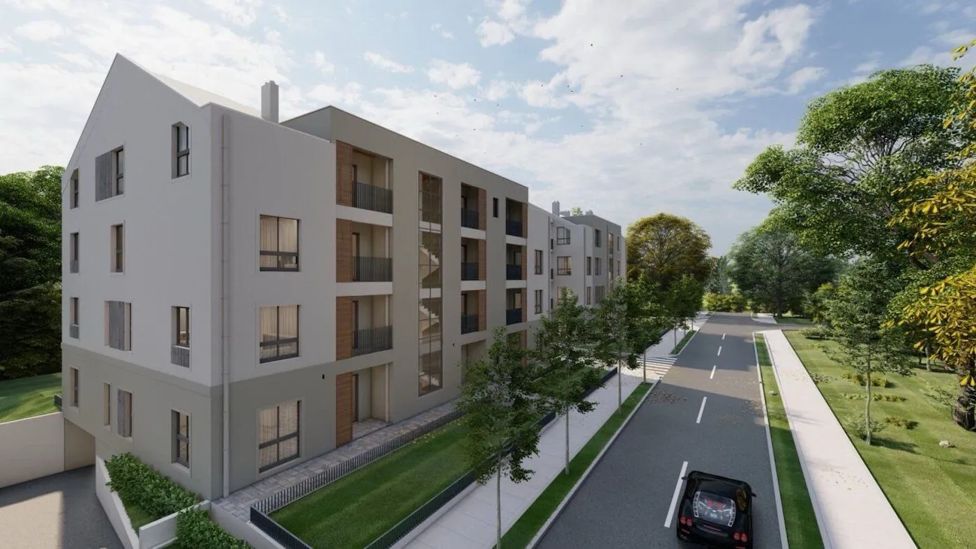 Exterior view of a modern residential building with a street and greenery.