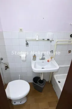 Manje kupatilo sa umivaonikom, wc šoljom i tuš kabinom obloženo belim pločicama. - image 16