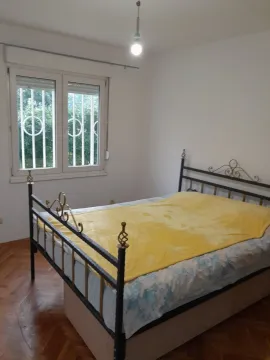 Spavaća soba sa metalnim krevetom i žutim prekrivačem pored prozora. - image 15