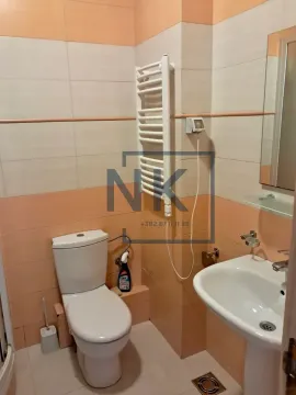 Bathroom equipped with a toilet, washbasin, and towel radiator. - image 5