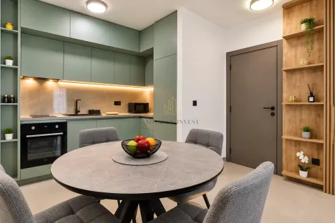 Modern kitchen with green cabinets, dining table and grey chairs. - image 4