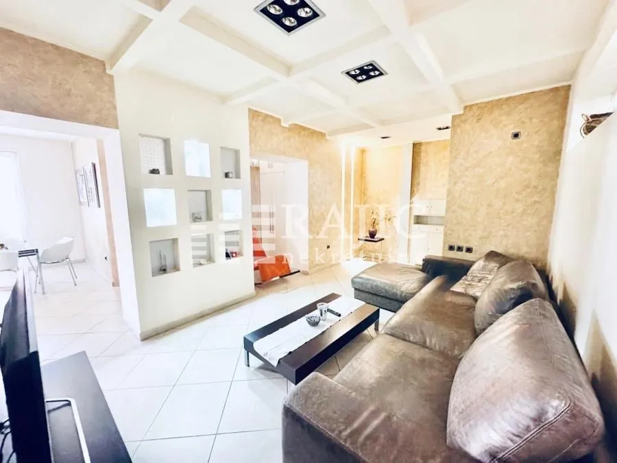 Spacious and bright living room with a sofa and decorative ceiling.