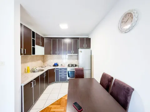 Kitchen with dining area equipped with dark cabinets and a refrigerator. - image 2