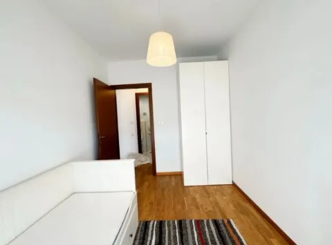 Manja spavaća soba sa krevetom, bijelim garderoberom i drvenim podom. - image 7