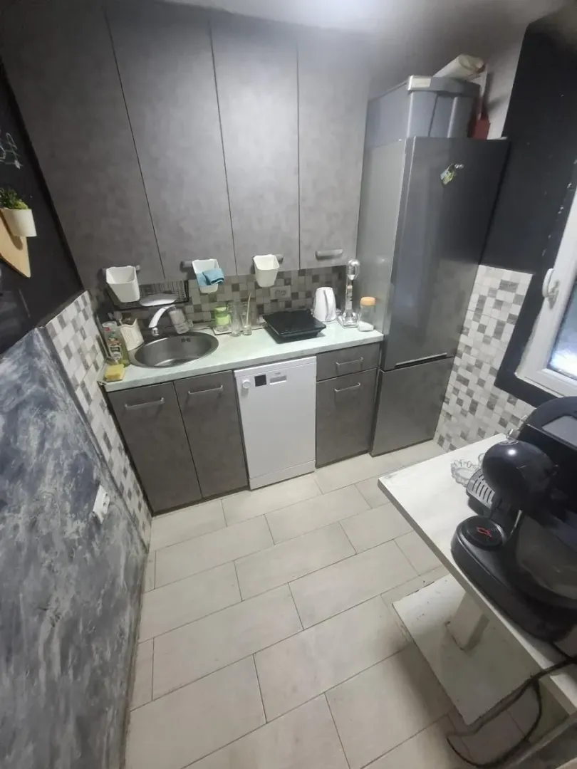 Smaller kitchen with grey cabinets and built-in appliances.
