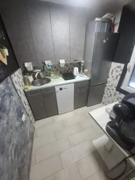 Smaller kitchen with grey cabinets and built-in appliances. - image 6