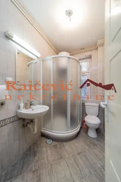 Small bathroom with a shower cabin, washbasin, and toilet. - image 4