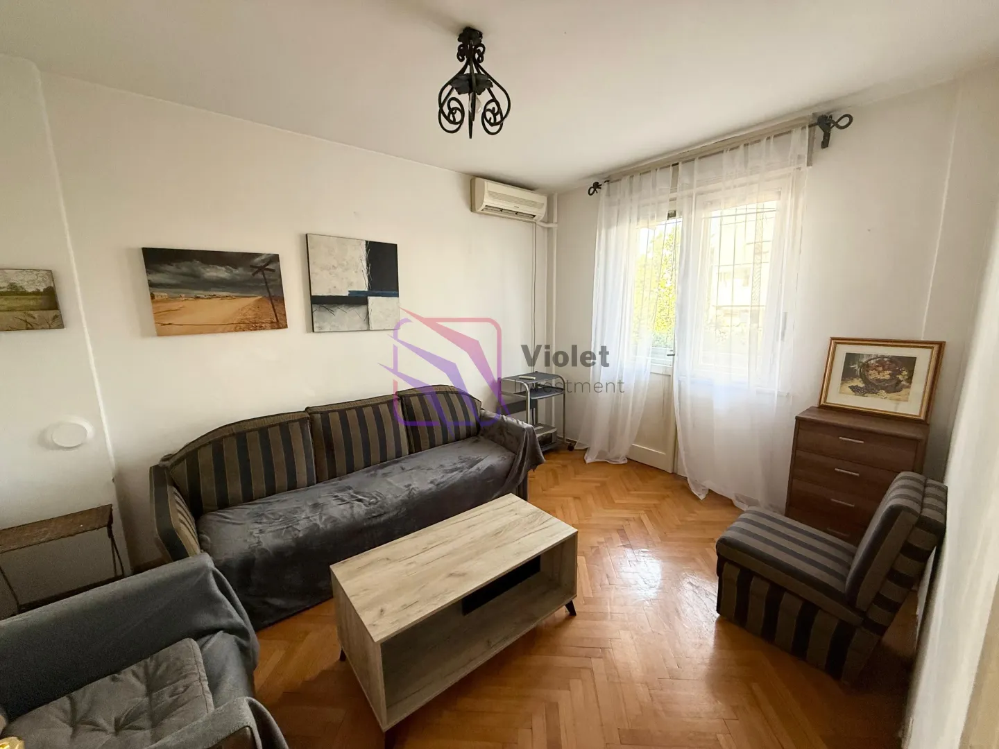 Living room with sofa, coffee table, and parquet flooring.