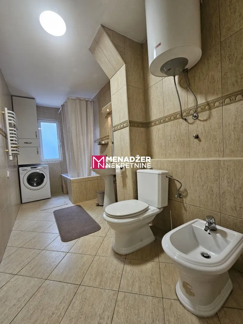 Fully equipped bathroom with a bathtub, sanitary ware, and a washing machine.