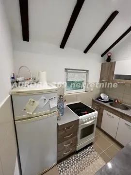 Manja kuhinja sa belim elementima, frižiderom i šporetom. - image 9