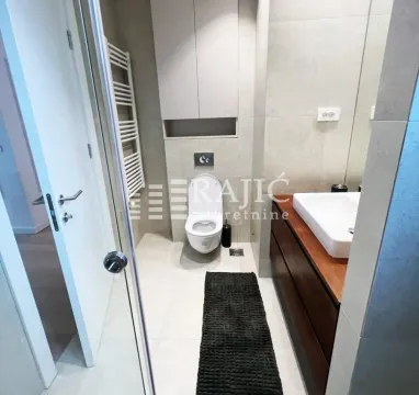 Modernly equipped bathroom with a washbasin, toilet, and shower cabin. - image 17