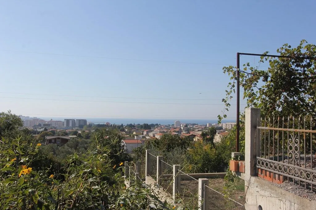 Pogled iz dvorišta na grad i more u daljini.
