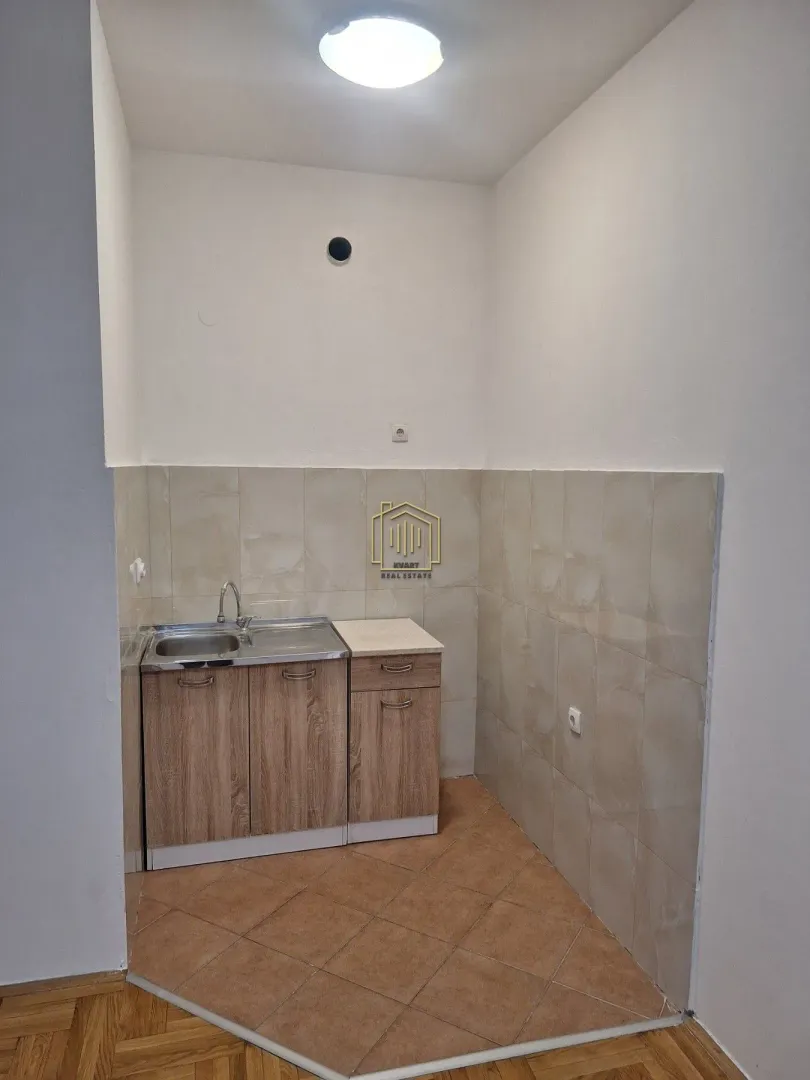 Small kitchen with a sink and wooden cabinets.