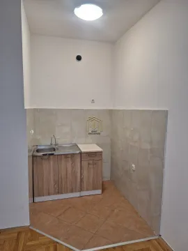 Small kitchen with a sink and wooden cabinets. - image 5