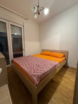 Bedroom with a double bed, laminate flooring, and balcony doors. - image 7