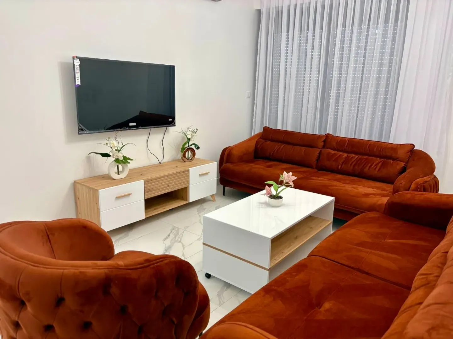 Furnished living room with a sofa set and television.
