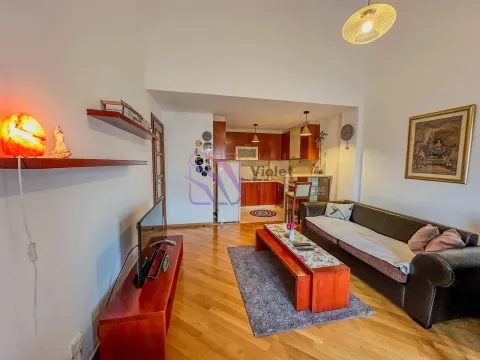Dnevni boravak sa garniturom i televizorom, sa pogledom na otvorenu kuhinju u pozadini. - image 3