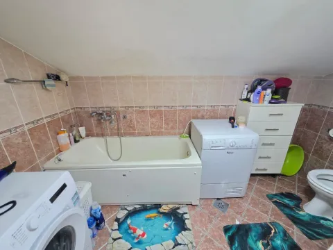 Kupatilo sa kadom, veš mašinom i pločicama na zidovima. - image 16