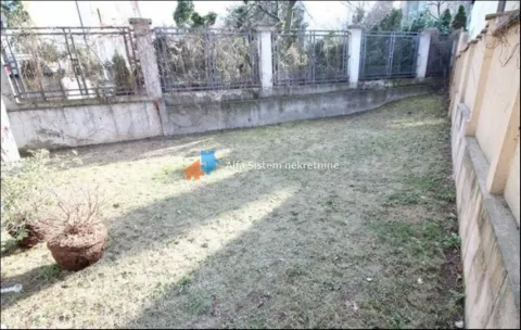 Manje travnato dvorište ograđeno zidom i metalnom ogradom. - image 3
