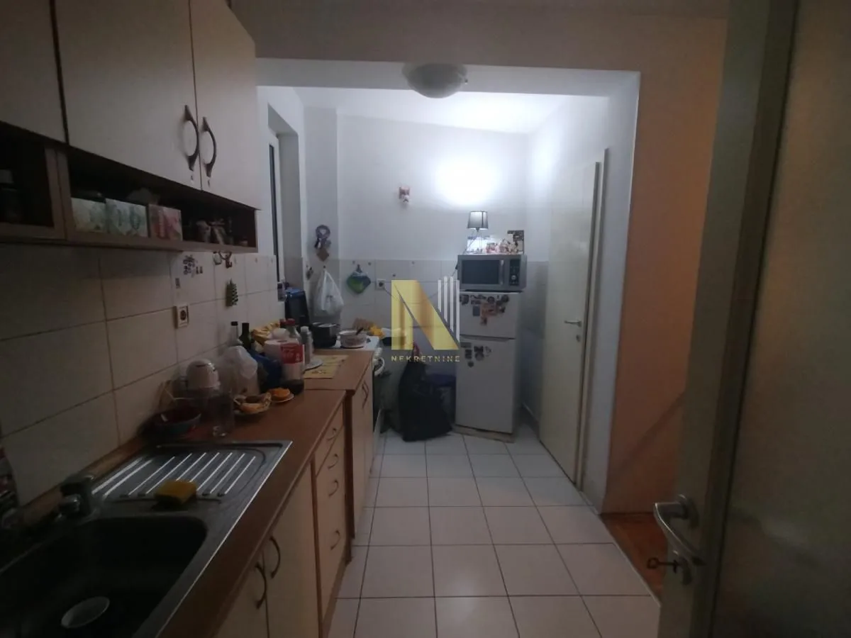 Manja kuhinja sa elementima i kućnim aparatima.