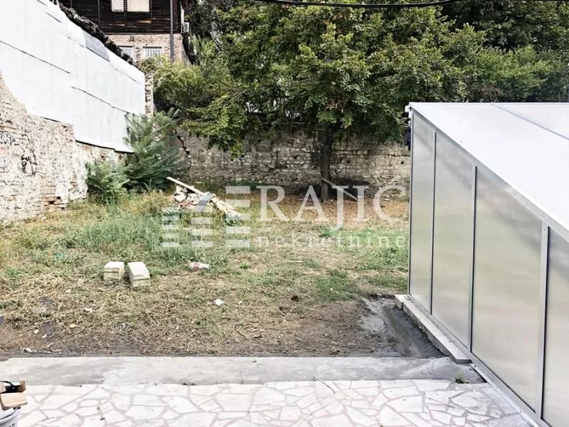 House yard with greenery and an auxiliary building.