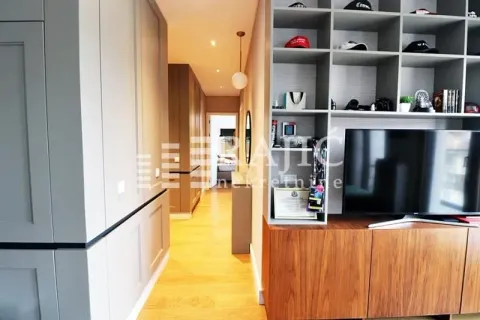 Living room with a TV, shelving unit, and a hallway passage. - image 8