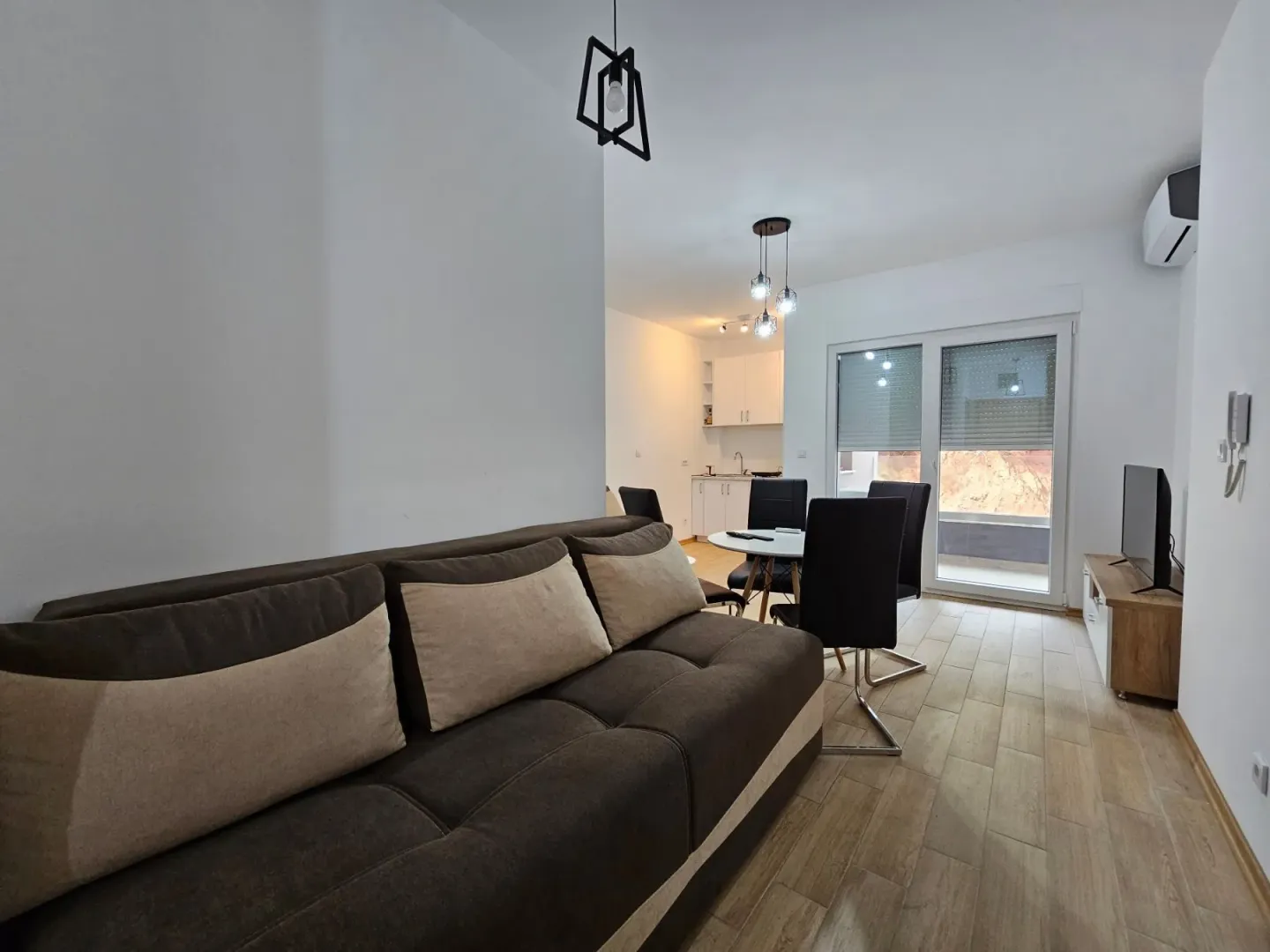 Living room with sofa, dining area, and access to the terrace.