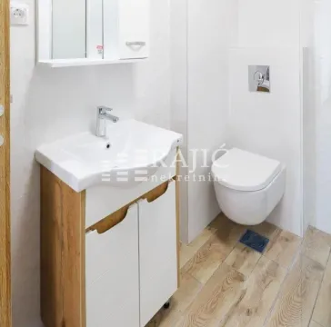 Modern bathroom with a sink, mirror, and toilet. - image 10