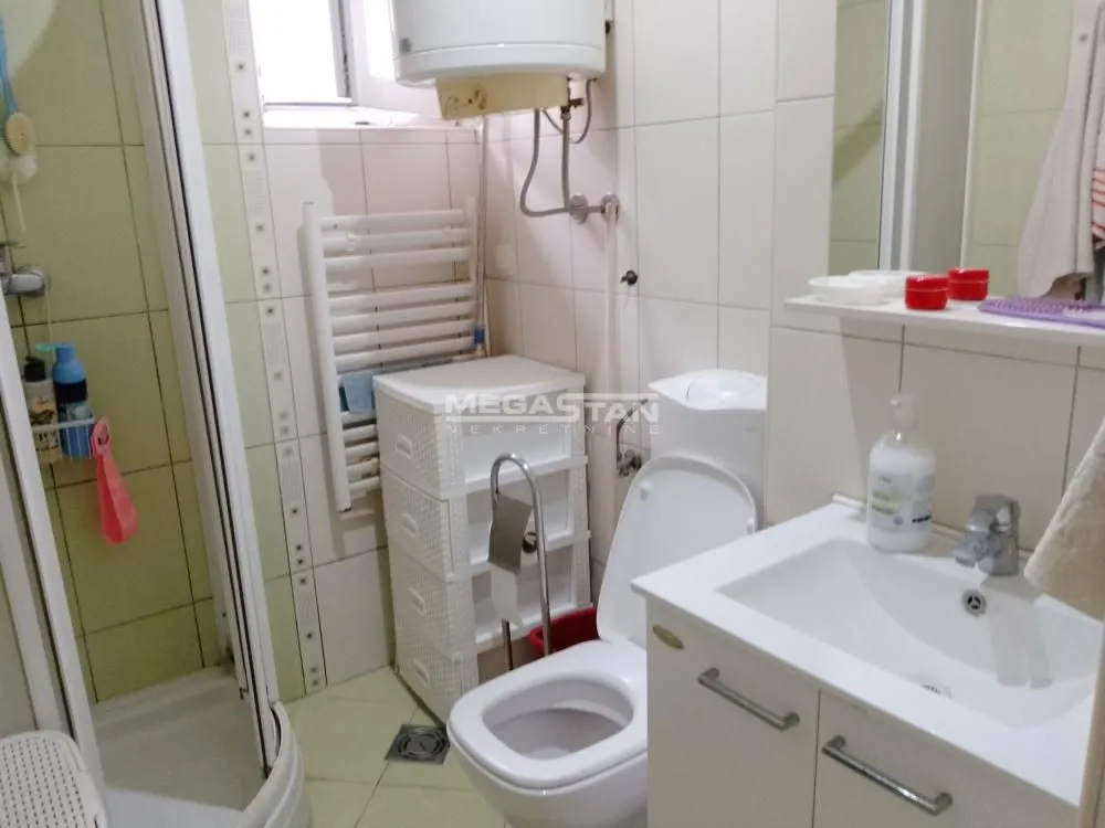 Kupatilo opremljeno tuš kabinom, umivaonikom i toaletom.