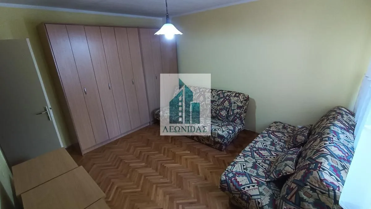 Furnished bedroom with a large wardrobe and two beds.
