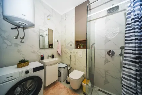 Savremeno opremljeno kupatilo sa tuš kabinom, umivaonikom i veš mašinom. - image 12