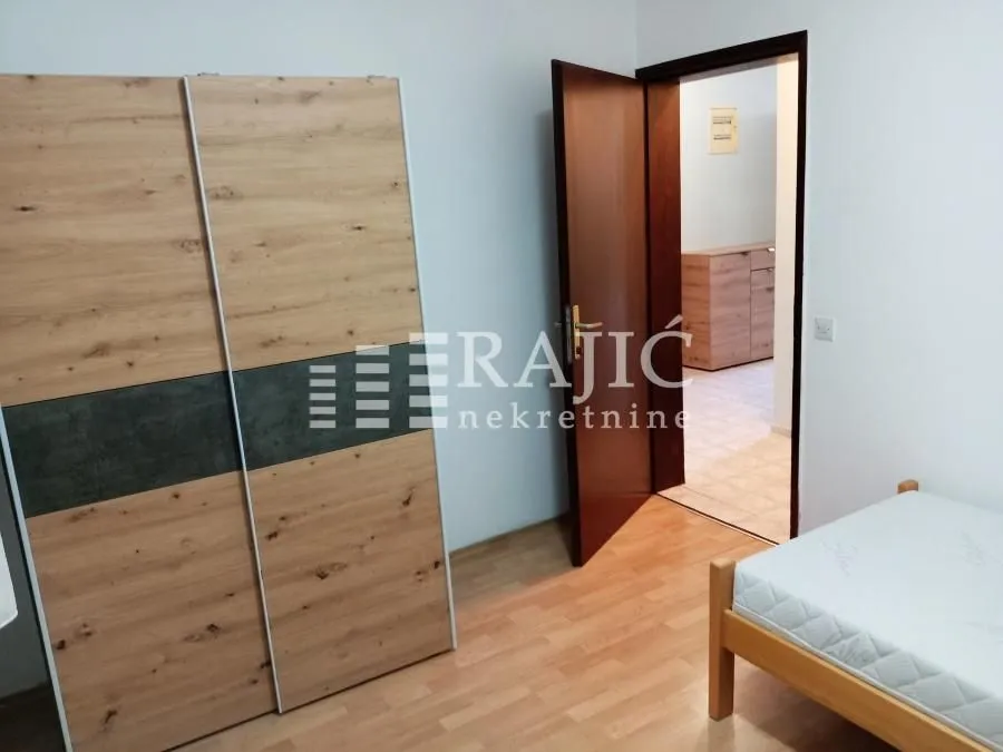 Furnished bedroom with a wardrobe and a bed.
