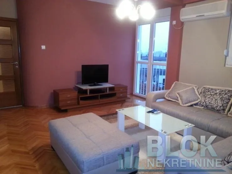 Living room with sofa, television and access to the terrace.