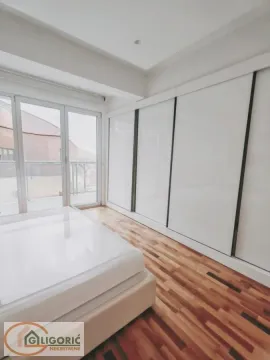 Bedroom with a large built-in wardrobe, bed, and balcony access. - image 8