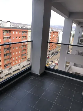 Spacious terrace with a glass railing and a view of surrounding buildings. - image 30