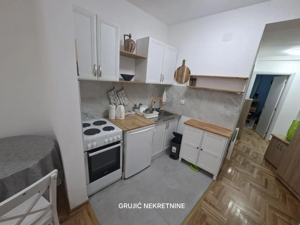 Small white kitchen with a stove and a sink.