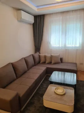 Bright living room with a large corner sofa and coffee tables. - image 2