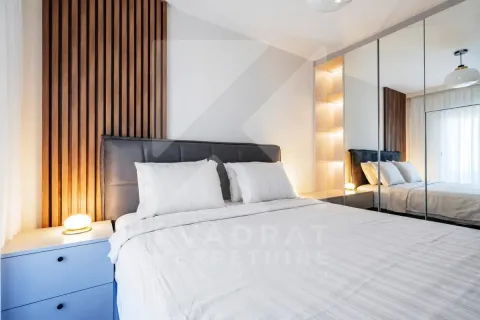 Modern bedroom with a double bed, wooden wall panel, and built-in mirrored wardrobe. - image 8
